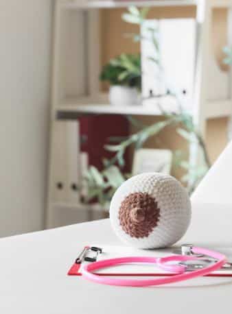 Main de sage-femme avec stéthoscope écoutant le cœur du bébé